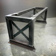 two metal and glass side tables on concrete floor with grey wall in the back ground