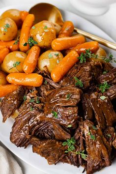 a white plate topped with meat and carrots next to potatoes on a tablecloth