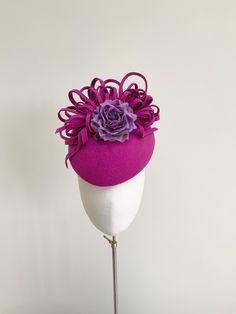 A beautiful pillbox style fascinator in striking fuchsia pink.  This elegant percher is made from fuchsia purple pink felt, which makes it a perfect all year round headpiece. It features a cascade of matching pink felt loops and twists which surround the top and back of the pillbox. Seated to the front is a rose made from a lilac purple shot silk dupion and silk organza, which reflects the light beautifully. This headpiece measures 20cm front to back and 17cm side to side. It is fitted with a fi Floral Fascinator, Race Day Hats, Floral Fascinators, Fuchsia Purple, Bride Floral, Ascot Hats, Pink Felt, Mother Of Bride, Wedding Hats