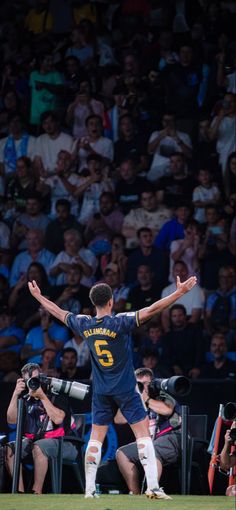 a soccer player with his arms outstretched in front of an audience