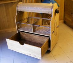 an old fashioned wooden dresser with drawers on the top and bottom drawer open, in a kitchen