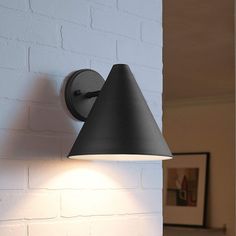 a black lamp on a white brick wall