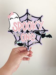 a hand holding up a spooky one sign