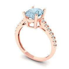 a rose gold engagement ring with an aqua blue topazte and diamonds on the side