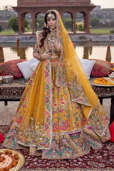 a woman in a yellow bridal gown standing next to some donuts on a table