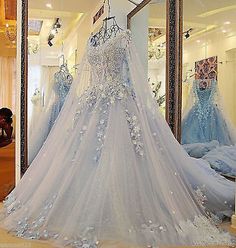 a wedding dress is displayed in front of a mirror and mannequins are behind it