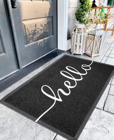 a black door mat with the word hello written on it in front of a house