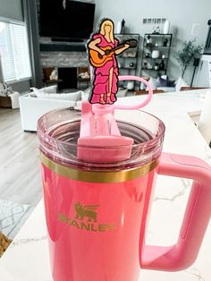 a pink blender sitting on top of a counter next to a white coffee cup