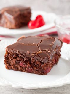 two pieces of chocolate cake sitting on top of a white plate next to each other