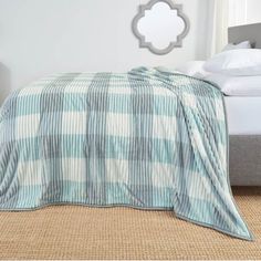 a bed with a blue and white blanket on top of it