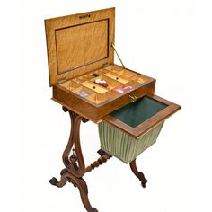 an old fashioned wooden game table with drawers on the top and one drawer open to reveal its contents