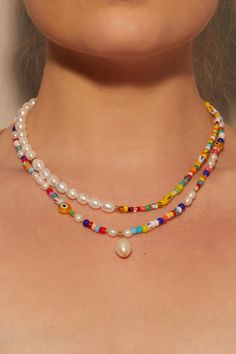 a woman wearing a multicolored necklace with pearls