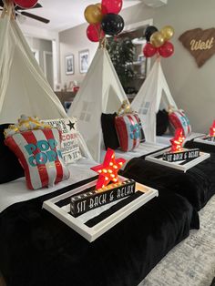 a bed with pillows and lights on it in a room that has balloons hanging from the ceiling