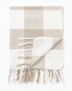 a beige and white checkered blanket with fringes