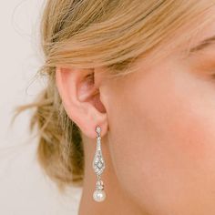 a close up of a person wearing some kind of earring with pearls on it