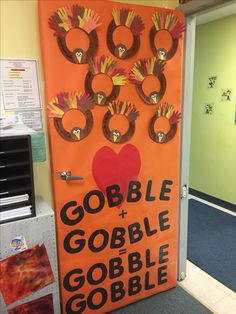 an orange bulletin board with handprints on it and the words gobble + gobble = gobble