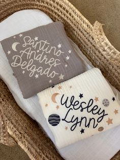 two pillows sitting on top of a wicker basket filled with blankets and other items