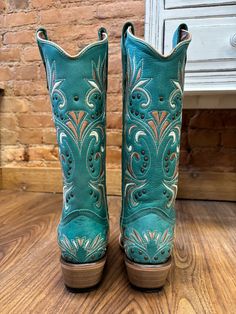 Enhance your bold cowgirl style with these Corral Women's Vintage Blue Snip Toe Cowgirl Boots, showcasing intricate embroidery and stud accents. Authentic Cowgirl Style Cowhide Leather Vamp Pig Leather Lining Snip Toe 13" Shaft Height 14" Circumference Macocel 2" Cowboy Heel Leather Sole Goodyear Welt Construction Color: Blue Western Turquoise Boots For Fall, Fitted Turquoise Boots For Ranch, Green Western Boots For Rodeo, Western Turquoise Boots For Spring, Turquoise Western Boots For Spring, Bohemian Snip Toe Boots For Rodeo, Western Turquoise Boots For Rodeo, Western Style Embroidered Boots, Western Hand Tooled Boots For Festivals