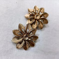 Trifari Flower Earrings 1950s ABOUT | High quality vintage American jewelry, a pair of clip-on earrings by Trifari Crown. The earrings are shaped like flowers with overlapping petals and are in gold-colored metal with brushed workmanship. They are a famous Trifari design from the 1950s, retro style. SIZE & MEASUREMENTS | Diameter 3 cm CONDITIONS | The earrings are in good condition, slight losses to the gold plating. TIPS | Flower earrings that cannot be missing from the collection of an enthusi Vintage Gold Flower-shaped Earrings, Vintage Gold Flower Shaped Earrings, Vintage Metal Flower Earrings, Vintage Yellow Gold Flower Earrings, Vintage Yellow Gold Flower Shaped Earrings, Vintage Flower Shaped Clip-on Earrings, Vintage Clip-on Flower Earrings, Vintage Flower Shaped Earrings For Anniversary, Vintage Gold Flower Clip-on Earrings