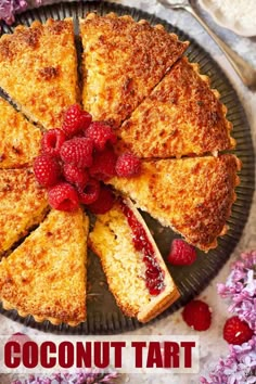 a cake with raspberries is cut into slices and served on a platter