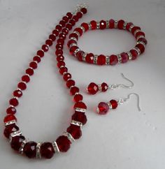 This is a beautiful dark red necklace, bracelet and earring set.  The necklace is made with 12 x 8 mm, 10 x 8 mm and 8 x 6 mm red rondelle faceted beads and 8 mm square crystal diamantes. The necklace is approximately 45 cm drop but can be made longer if required. The bracelet is made with 10 x 8 mm crystals and 8 mm round diamante spacers and fits an average 20 cm wrist but again can be made bigger or smaller on request. The earrings are  sterling silver and the drop is approximately 2 cm.  The set comes in an organza bag making a perfect gift or treat. Red Jewelry With Faceted Beads, Red Sterling Silver Party Jewelry Sets, Red Faceted Jewelry For Formal Occasions, Red Sterling Silver Jewelry Sets For Party, Formal Red Faceted Jewelry, Adjustable Red Formal Jewelry, Red Faceted Beads Jewelry For Valentine's Day, Red Adjustable Round Jewelry Sets, Red Adjustable Classic Jewelry