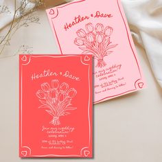 two wedding cards with flowers on them sitting next to each other, one is pink and the other is red