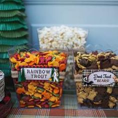 three plastic containers filled with different types of snacks on a table next to other food items