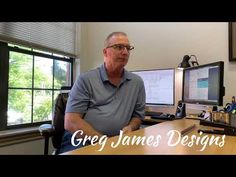 a man sitting at a desk in front of two computer monitors with the words grey james designs on it