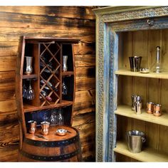 a wooden shelf filled with wine glasses next to an old fashioned cabinet full of cups