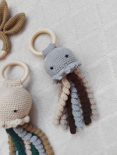 two crocheted octopus keychains are on a white tablecloth, one is brown and the other is green