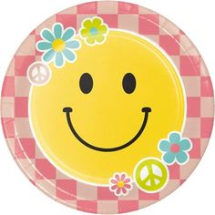 a paper plate with a smiley face and flowers in the center on a checkered tablecloth background