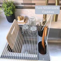 two silverware caddies sitting on top of a sink next to a cutting board