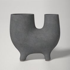 a gray vase sitting on top of a white table