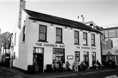 black and white photograph of people sitting outside the harbour bar