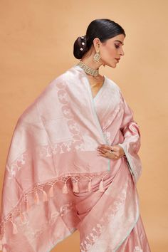 Look your ethnic best at weddings and special occasions in this powder pink Katan Banarasi saree. It is adorned with zari buta and has a zari border. The saree comes with a blue blouse piece. Disclaimer: The shown stitched blouse on the model is for display purpose only. The saree comes with a matching blouse piece and finished with fall and piko. Tussar Silk Sarees, Indian Clothing Store, Fashion Journals, Tussar Silk Saree, Banarasi Saree, Indian Clothing, Traditional Fabric, Banarasi Sarees, Pure Silk Sarees