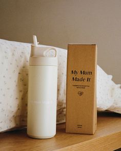 thermos bottle is next to an empty box on a bed