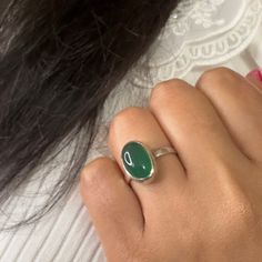 Get ready to make a statement with our Haraye Silver Adjustable Ring, an on-trend gorgeous piece of jewellery that beautifully showcases the vivid forest green hue of the green onyx gemstone. May birthstone is also a popular 2023 trend in gemstone jewellery, thanks to its mesmerizing colour and unique properties. Green onyx gemstone, popular choice among crystal enthusiasts, is a variety of chalcedony stone. Green onyx believed to harness positive communication energy of Mercury. It is also known to be a symbol of renewal and growth, making it a great gift for those who are going through a transformative period in their journey. One UK V size non-adjustable and 2 adjustable rings are available. This beautiful silver ring is handmade with love and care, ensuring that each piece is unique an Oval Green Onyx Gemstone Ring, Oval Green Onyx Rings, Elegant Handmade Green Moonstone Ring, Handmade Elegant Green Moonstone Ring, Green Onyx Rings For Gifts, Green Oval Chalcedony Rings, Oval Green Chalcedony Rings, Green Oval Fusion Rings, Handmade Green Chalcedony Rings