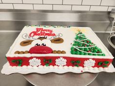 a decorated sheet cake on top of a metal counter with frosting and icing