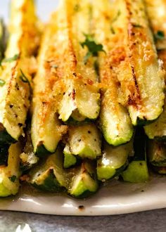 grilled zucchini with parmesan cheese and herbs on a white plate