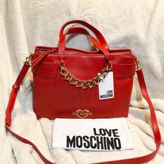 Love Moschino Borsa Pu Rosso Satchel Shoulder Bag Red Gold Chain Logo. Love Moschino Borsa Pu Rosso Satchel New With Tags! Gold-Toned Brand Logo Hardware And Chain Accents Decorate A Dual Top Handled Red Satchel Bag With An Optional Shoulder Strap. - Dual Top Handles - Detachable, Adjustable Shoulder Strap - Zip Top Closure - Exterior Features Brand Logo Hardware And Heart Chain Detail - Imported Approx. 9.5" H X 13" W X 3" D - Approx. 4" Handle Drop, 22" Adjustable Strap Drop Length Pu Exterior Chain Logo, Red Satchel, Gold Tote Bag, Soft Leather Handbags, Brown Leather Satchel, Brown Leather Bag, Leather Satchel Bag, Heart Chain, Bags Logo