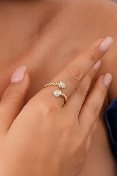 a close up of a person's hand with a ring on her left finger