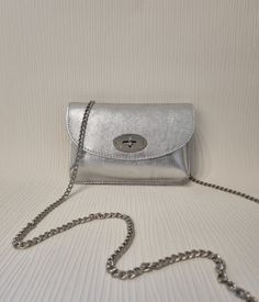 Bag Dimension: Hx15cm Wx22cm Dx7cm Chain Strap full length is 122cm Specification: Twist lock Closure Silver tone metal Hardware Detachable strap Material: Real Leather Silver Shoulder Bag For Party, Silver Mobile Phone Shoulder Bag For Party, Formal Silver Bag With Chain, Silver Evening Shoulder Bag, Elegant Silver Bag With Chain, Elegant Silver Bags With Chain Detail, Silver Evening Shoulder Bag With Chain Strap, Silver Formal Bag With Chain Strap, Trendy Silver Clutch Evening Bag