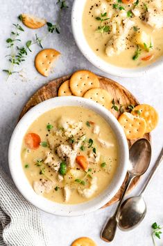 two bowls of soup with crackers on the side