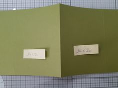 two pieces of paper are taped to the side of a piece of green material with writing on it