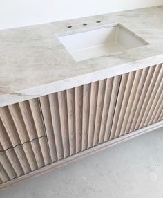 a white sink sitting on top of a wooden cabinet