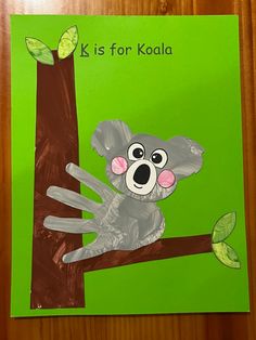 a paper cut out of a koala sitting on a tree branch with the words k is for koala