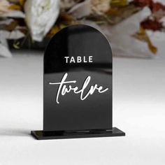 a black table sign with the word table written in cursive writing on it