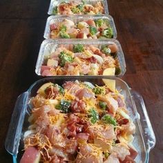 four plastic containers filled with food on top of a wooden table