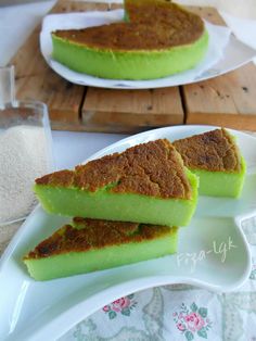 two white plates topped with green desserts on top of a wooden table next to each other