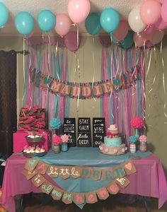 a table topped with lots of cake and balloons